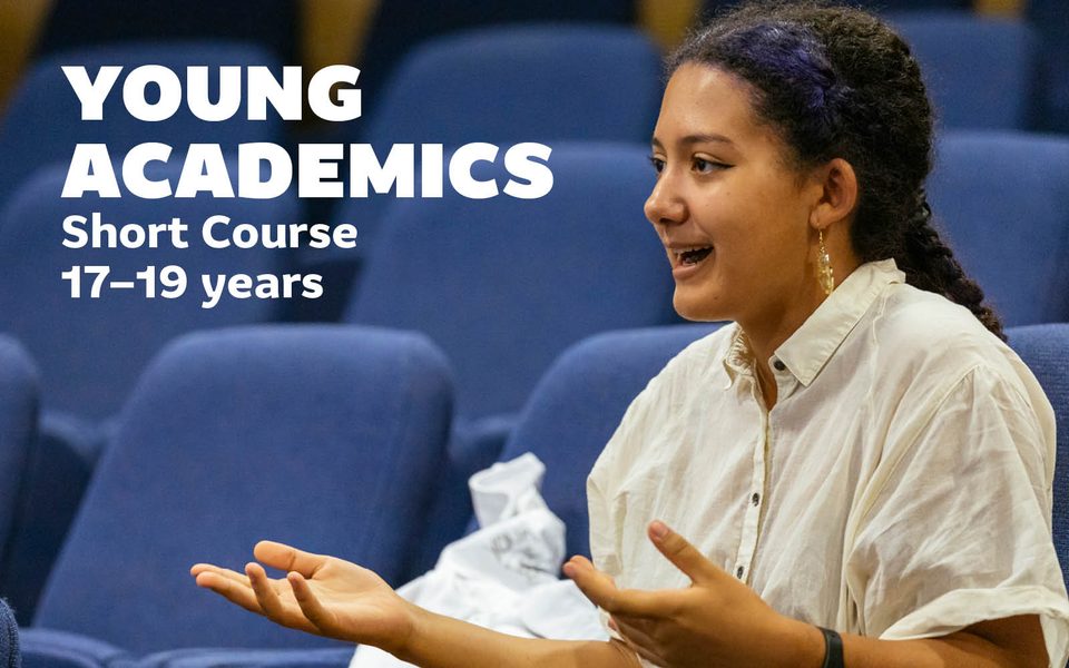 Young female sat talking in a lecture theatre. Overlaid text reads Young Academics Short Course 17-19 years.