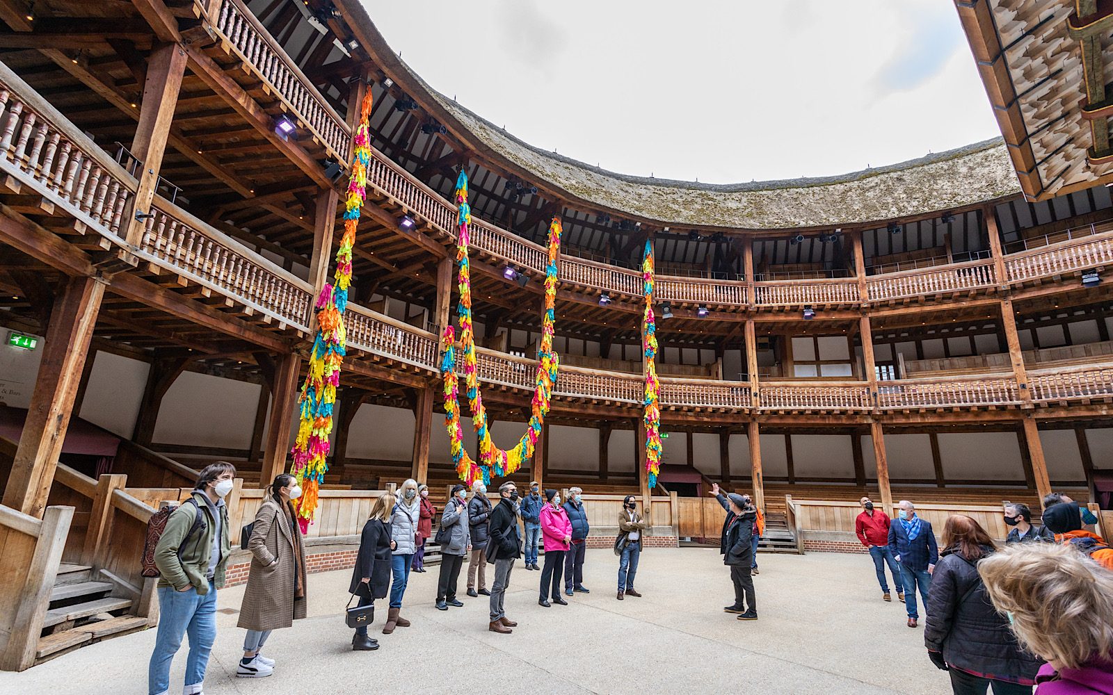 A group of people stand in the middle of a roofless theatre