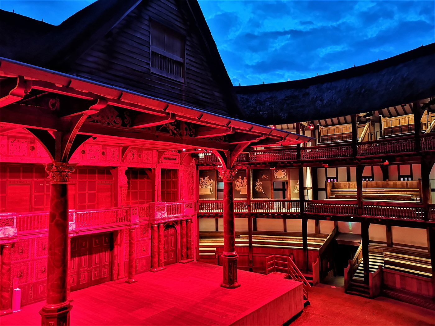 The stage of the Globe Theatre is lit by red lights.