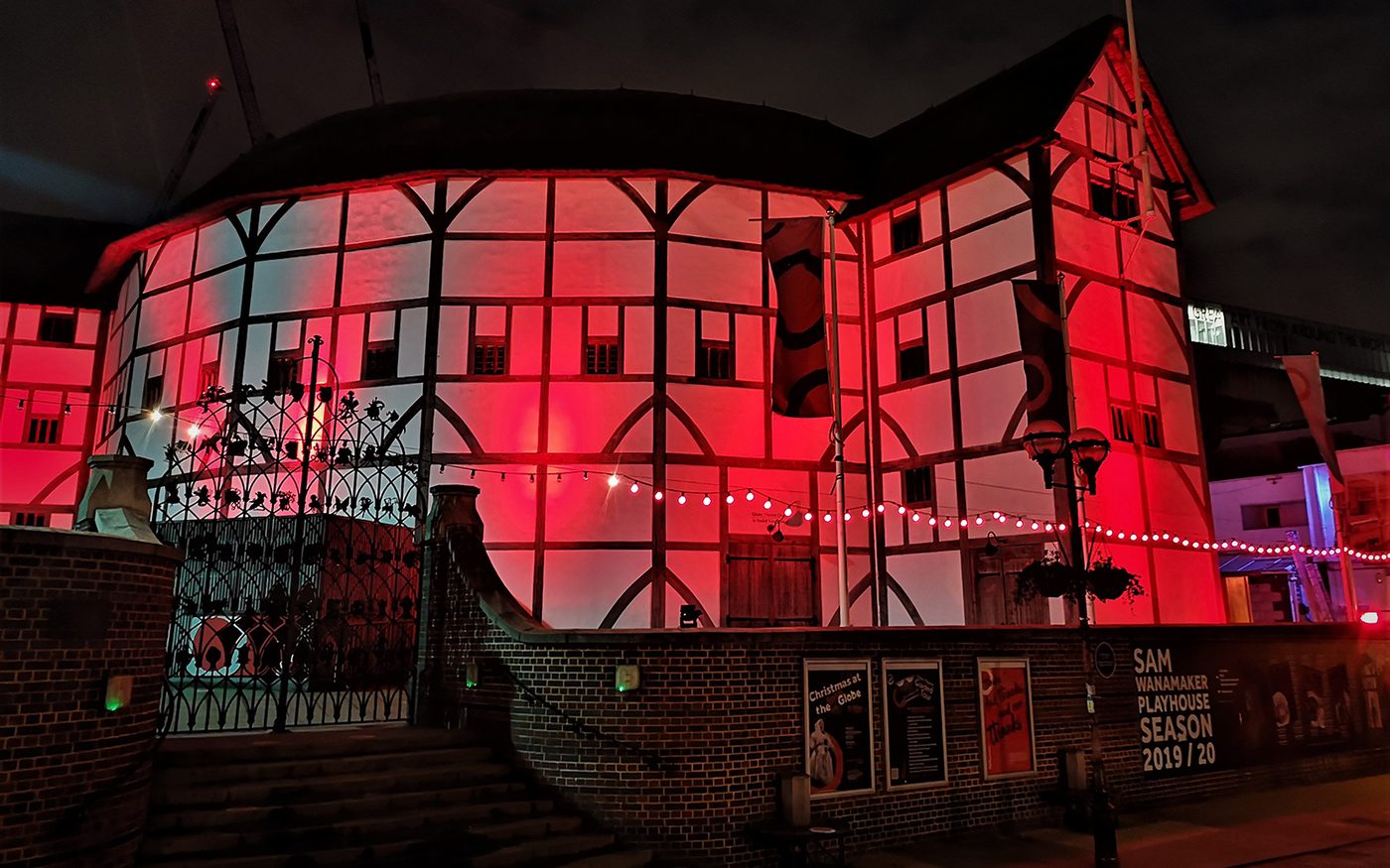 The Globe Theatre on bankside at night, lit by red light.