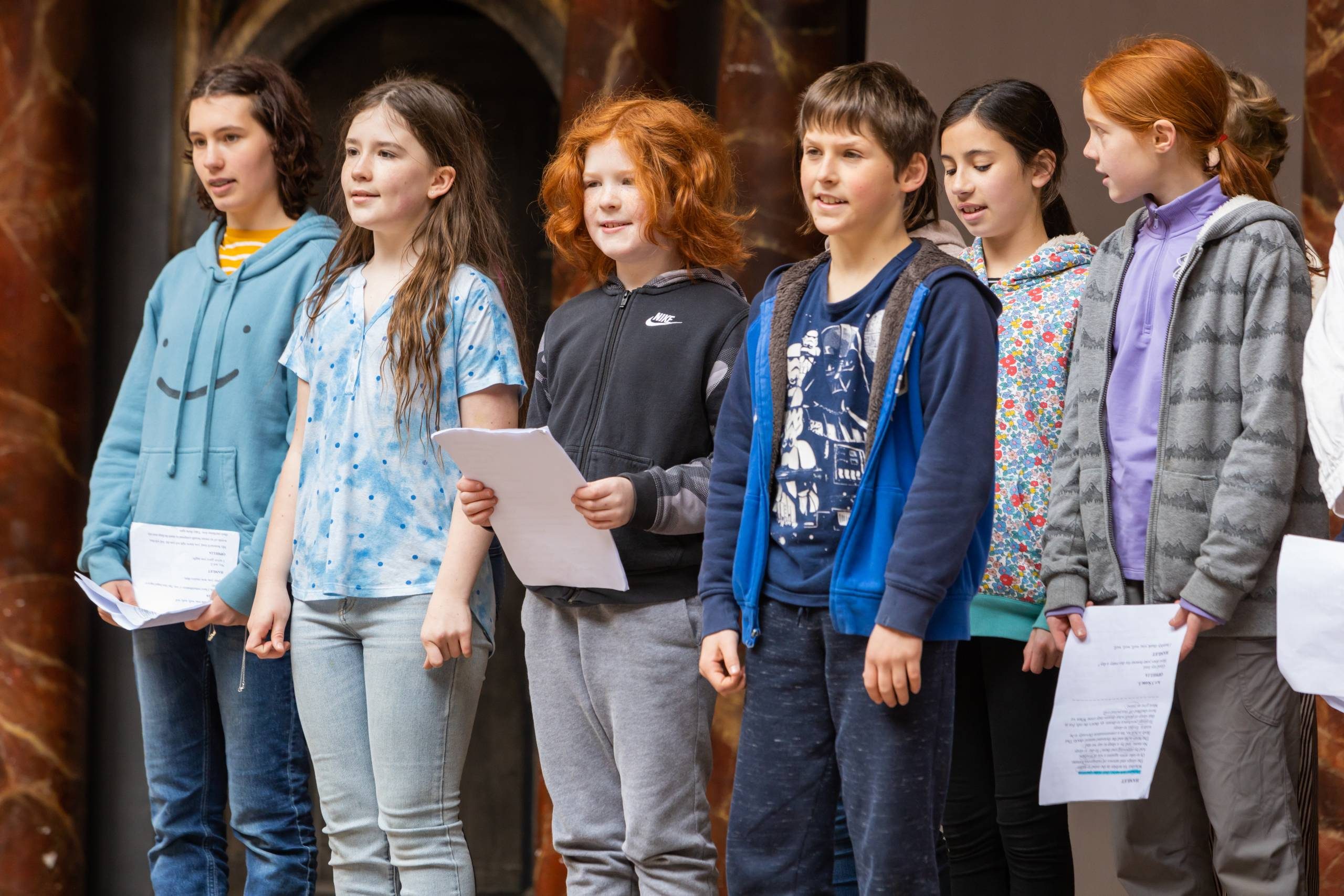 A group of young actors standing on stage