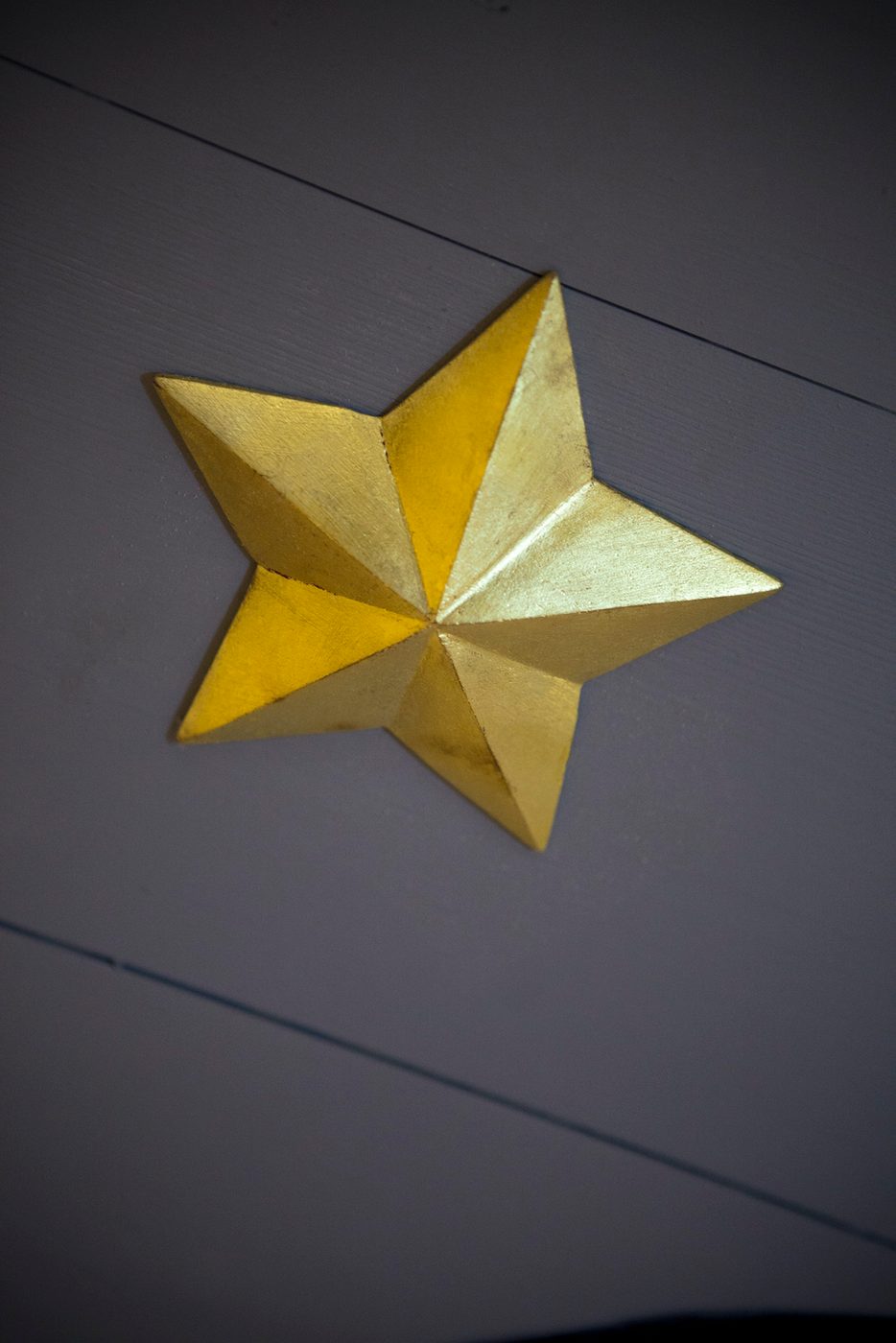 A gold star on a black wall