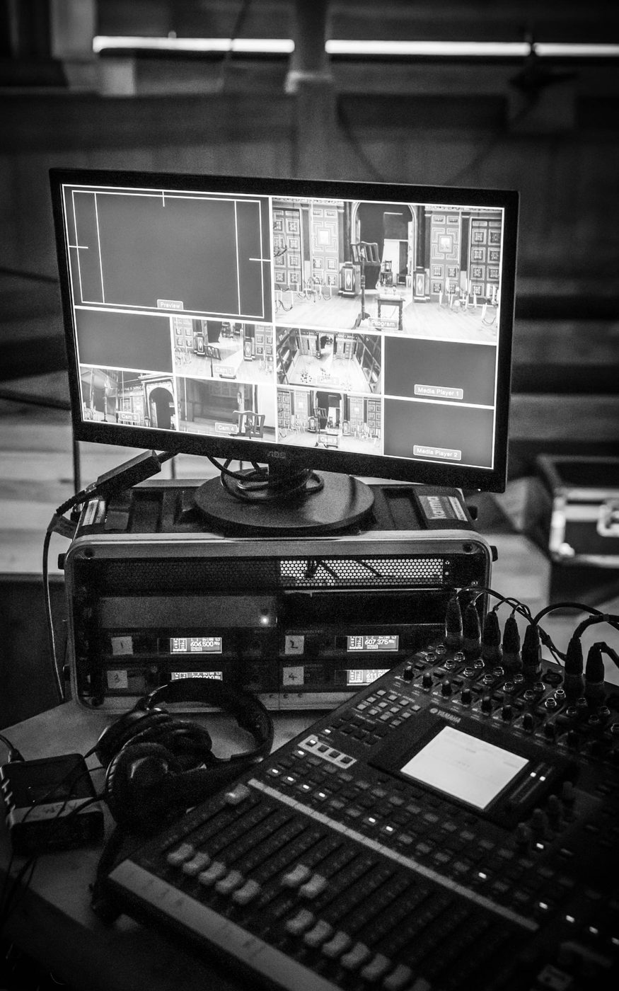 A monochrome image of recording equipment and a screen showing different camera angles