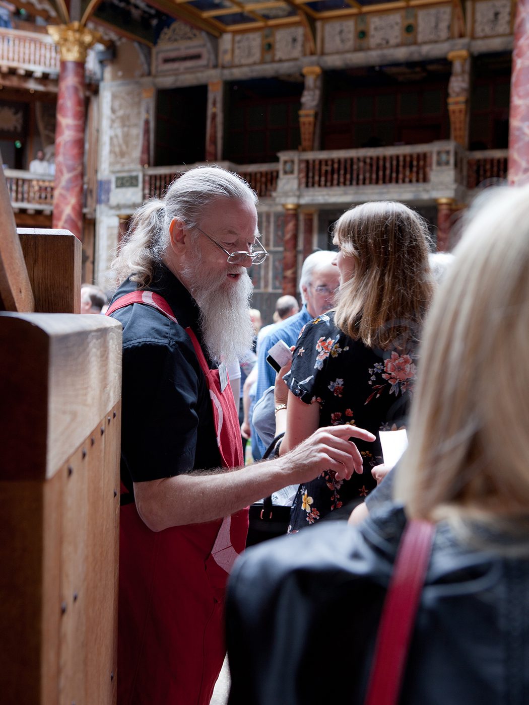 A man takes a ticket of an audience member entering a theatre