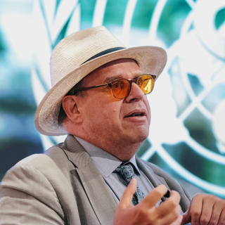 Picture of Christopher Bailey wearing a suit, sunglasses and a beige hat.