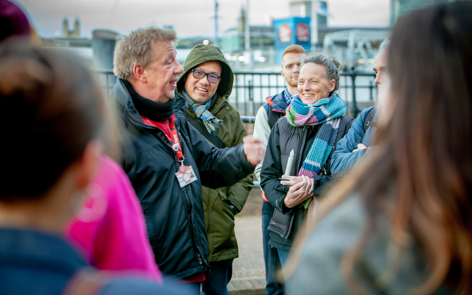 People listening to a person speaking and smiling